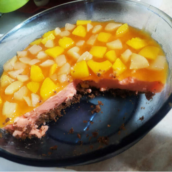 cheese cake with peach jelly, fruits and chocolate cookies